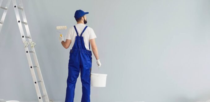 Painter and decorator painting an interior wall